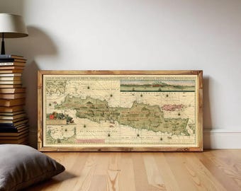 Puede incluir: Un mapa antiguo enmarcado de Java, Indonesia, que presenta cartografía detallada, rosas de los vientos e ilustraciones náuticas en tonos tierra de beige, verde y rojo, dentro de un marco de madera rústica.