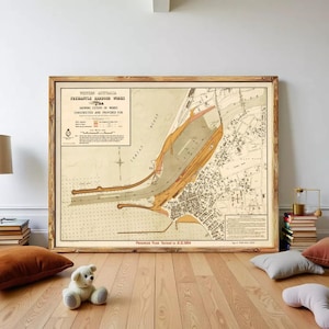 Puede incluir: Un mapa antiguo enmarcado de las obras del puerto de Fremantle en Australia Occidental, que muestra la extensión de las obras construidas y provistas. El mapa está en un marco de madera y se exhibe sobre un suelo de madera.