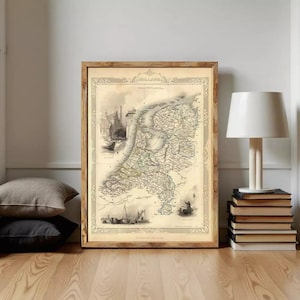May include: A framed vintage map of Holland in sepia tones, featuring intricate cartographic details, nautical illustrations, and architectural sketches. The map is enclosed in a wooden frame with a decorative border and the text HOLLAND at the top.