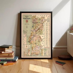 Op de afbeelding: Een ingelijste vintage kaart van Portugal en Spanje, met de tekst "MAPA PORTUGAL CONTINENTAL" bovenaan. De kaart is gedetailleerd met wegen, steden en geografische kenmerken, in tinten groen, bruin en beige. De lijst is zwart.