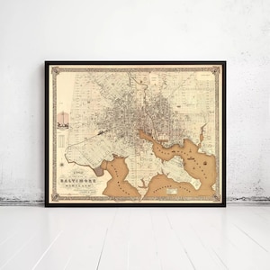 May include: A framed vintage map of Baltimore, Maryland, in sepia tones. The map details the city's layout, including streets, waterways, and surrounding areas. The map is enclosed in a black frame, suitable for home or office decor.