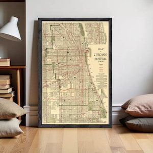 Può includere: Una mappa vintage incorniciata di Chicago del 1906 con dettagliati tracciati stradali, linee di griglia e indicatori geografici in tonalità beige, nero e rosso. Il testo recita Map of Chicago with the New Street Names 1906, inclusi i dettagli della legenda.