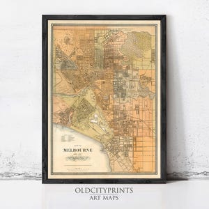 Peut inclure: Une carte de style ancien encadrée intitulée Plan of Melbourne and its Suburbs, présentant un quadrillage de rues et des détails géographiques dans des tons de beige, brun et crème. L'impression est dans un cadre en bois sombre.