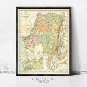 May include: A framed vintage map of Congo, with detailed geographical information and a variety of colours. The map is enclosed in a black frame and is displayed against a white wall. The text "OLD CITY PRINTS ART MAPS" is visible at the bottom.