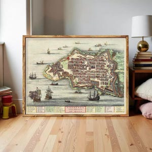 May include: A framed historical map print titled VALLETTA DE MALTA, depicting the fortified city surrounded by water with numerous sailing ships. The map features detailed street layouts, coastal fortifications, and a legend at the bottom.