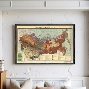 May include: A framed wall map titled POCHVENNAYA KARTA SSSR, depicting the soil types of the Soviet Union in various colors. The map features a detailed legend at the bottom, set against a cream background with a dark wood frame.
