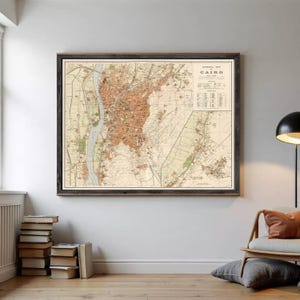 Może przedstawiać: Oprawiona zabytkowa mapa zatytułowana General Map of Cairo, Egypt, przedstawiająca szczegółowe linie topograficzne, układy miejskie i rzekę Nil w odcieniach beżu, piasku i brązu, z legendą w prawym górnym rogu.