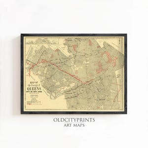 May include: A framed vintage map of the Borough of Queens, City of New York, featuring a cream-colored background with black street grids and a prominent red line indicating a transit route. The text reads Map of the Borough of Queens City of New York.
