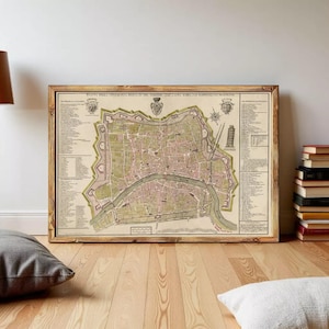 Può includere: Mappa antica incorniciata di una città, con un layout dettagliato con strade, edifici e un fiume. La mappa è in una cornice di legno, con una tavolozza di colori sbiaditi beige, rosa e verde. La mappa include testo ed elementi decorativi.