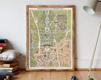 May include: A framed vintage-style map titled VERSAILLES ET SES PROMENADES, featuring a detailed layout of the palace grounds and surrounding streets in shades of olive green, soft peach, and cream, enclosed in a simple brown wooden frame.