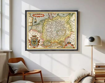 May include: A framed antique-style map titled GERMANIA, featuring detailed cartography with yellow, beige, and red tones. The map includes a prominent coat of arms on the left and decorative cartouches, all enclosed in a dark wooden frame.