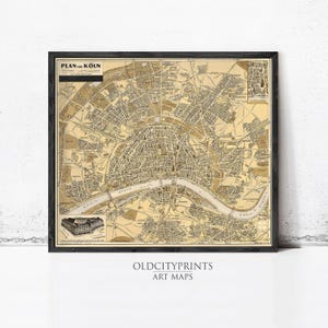 May include: Framed vintage map of Cologne, Germany, in sepia tones. The map, titled "PLAN von KOLN," features detailed city streets, the Rhine River, and architectural illustrations. The frame is black, and the print is from OLD CITY PRINTS.