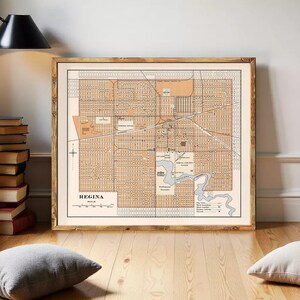 May include: A framed vintage map of Regina, Saskatchewan, Canada, in a warm color palette. The map features detailed street layouts, parks, and the Wascana Creek. The word "Regina" is printed at the bottom.