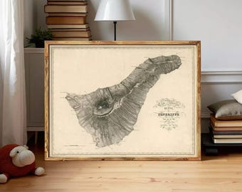 May include: A framed vintage map of Tenerife, Canary Islands, in a wooden frame. The map is in black and white, with detailed topographical features. The frame is a warm brown color, and the map is displayed in a room with a lamp and books.