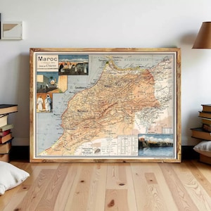 Puede incluir: Un mapa antiguo enmarcado de Marruecos, con información geográfica detallada e ilustraciones. El mapa está en un marco de madera y se muestra sobre un suelo de madera de color claro. El mapa incluye el texto "Maroc" y otros textos en francés.