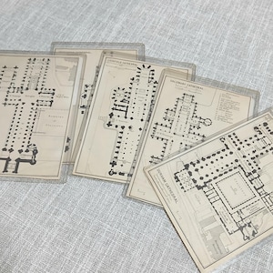 May include: A collection of architectural blueprints of cathedrals, including Durham Cathedral, Salisbury Cathedral, and Lichfield Cathedral. The blueprints are in black and white, with detailed layouts of the buildings. The blueprints are in clear plastic sleeves.