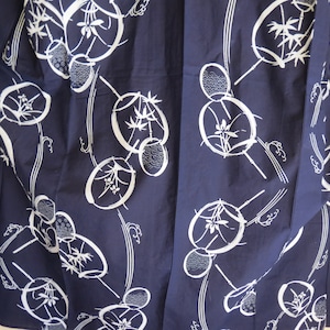 May include: Navy blue fabric with a repeating white pattern of stylized fans, bamboo, and wave-like designs. The fabric appears to be a lightweight cotton or linen, suitable for clothing or home decor.