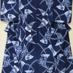 May include: Navy blue kimono with a white fan and floral pattern. The Japanese garment features a repeating design of stylized fans and maple leaves, with curved lines. The kimono is a traditional Japanese robe with wide sleeves.