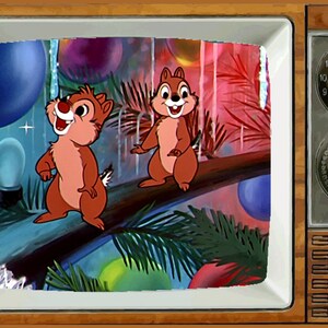 May include: A vintage television set with a brown wooden frame and a white screen. The screen shows a cartoon image of two chipmunks standing on a branch with colorful balloons and palm trees in the background.