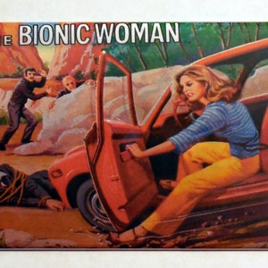 May include: A vintage magnet featuring a red car with an open door. A woman in a blue and white striped shirt and yellow pants is exiting the car. The text "THE BIONIC WOMAN" is printed at the top of the magnet.