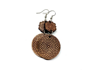 May include: A pair of wooden earrings with a geometric pattern. The earrings are brown and have a silver hook.