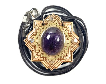 May include: A wooden pendant with a purple amethyst stone set in the center. The pendant is surrounded by a gold-colored mandala design and is attached to a black cord.