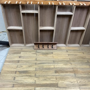 May include: A wooden shelf unit with multiple shelves and a small wooden coat rack with hooks underneath.