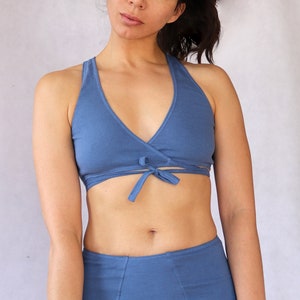 Peut inclure: Un soutien-gorge de sport bleu en forme de wrap avec un n&oelig;ud &agrave; l'avant. Le soutien-gorge est fait d'un tissu doux et extensible.