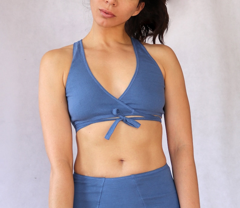 Peut inclure: Un soutien-gorge de sport bleu en forme de wrap avec un n&oelig;ud &agrave; l'avant. Le soutien-gorge est fait d'un tissu doux et extensible.