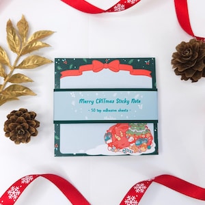 May include: A pack of 50 green and blue Christmas-themed sticky notes with a red bow and a festive illustration of a red and white Santa Claus character carrying a Christmas tree and presents. The text on the pack reads "Merry Critmas Sticky Note - 50 top adhesive sheets -"
