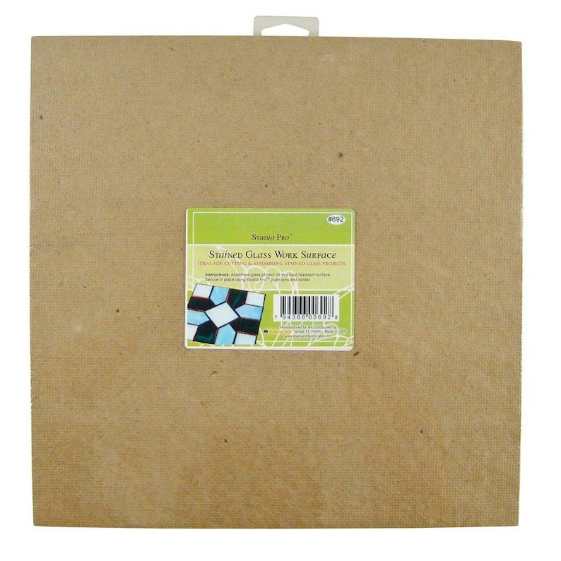 May include: A brown cardboard stained glass work surface, ideal for cutting and assembling stained glass projects. The packaging features a small image of a stained glass design and the text "Studio Pro" and "Stained Glass Work Surface".