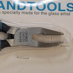 May include: Close-up of a silver-colored pliers with a blue handle. The pliers are labeled "CH NBGP CHOICE TAIWAN".