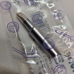 May include: A silver soldering iron tip with a pointed end. The tip is packaged in a clear plastic bag with a white label that has a barcode and the text "0-287-12".