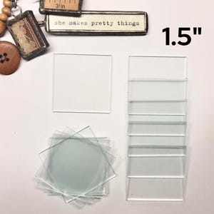 May include: A set of 1.5 inch square glass tiles. There are 7 tiles in total, with one tile separated from the rest. The tiles are clear and have a smooth surface. The text "she makes pretty things" is visible in the background.