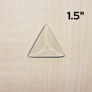 May include: A clear glass triangle with a 1.5 inch measurement. The triangle is a decorative piece.