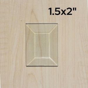 May include: A 1.5x2 inch raised panel cabinet door with a beveled edge. The door is made of wood and has a light brown finish.