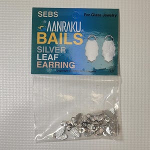 May include: A package of silver earring bails with a leaf design. The package includes a card with the text "SEBS AANRAKU BAILS SILVER LEAF EARRING" and two leaf earring illustrations. The bails are in a clear plastic bag.