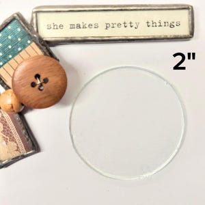 May include: A clear glass circle, 2 inches in diameter, on a white background. The text "she makes pretty things" is visible in the background.