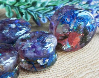 May include: Four purple, blue and silver resin ear gauges with embedded dried flowers and glitter.