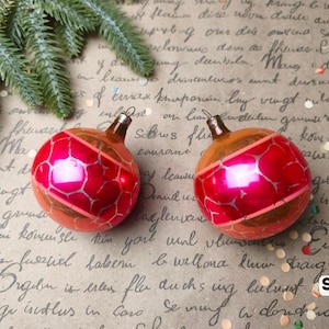 Puede incluir: Dos adornos navide&ntilde;os de vidrio redondos con una banda roja brillante con un patr&oacute;n plateado agrietado, contrastado por secciones doradas met&aacute;licas en la parte superior e inferior. Cada adorno tiene una tapa de metal. El texto SET 9 es visible.