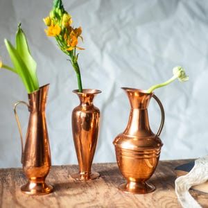 Vintage kopparvas, antik kanna, rustik metallinredning, lantlig blomkanna