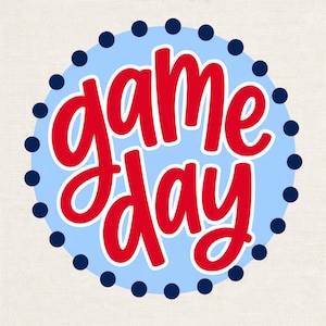 May include: A circular graphic design featuring the text "game day" written in a bold, red, cursive font. The text is centered on a light blue circular background, which is bordered by a ring of small, dark navy blue dots.