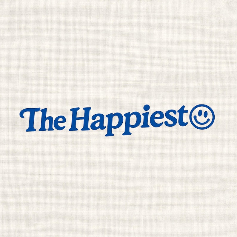 Puede incluir: Un dise&ntilde;o gr&aacute;fico que presenta el texto The Happiest en una fuente serif azul en negrita, seguido de un icono de cara sonriente circular azul. El dise&ntilde;o se sit&uacute;a sobre un fondo texturizado de color blanco roto que recuerda a una tela.