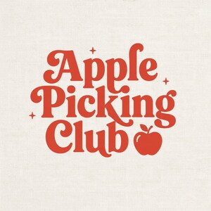 May include: A graphic design on a textured off-white background featuring the red text Apple Picking Club in a bold, rounded serif font. The design includes three small four-pointed star icons and a solid red apple icon next to the word Club.