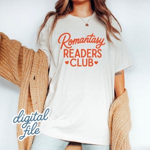 May include: Cream-colored t-shirt with the text "Romantasy READERS CLUB" in orange script and hearts. A tan cardigan is draped over the shoulders. The words "digital file" are written in a script font.