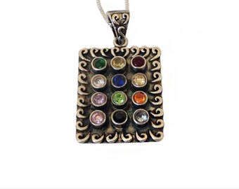 May include: A silver pendant with a square frame and 12 colorful gemstones. The pendant is on a silver chain.