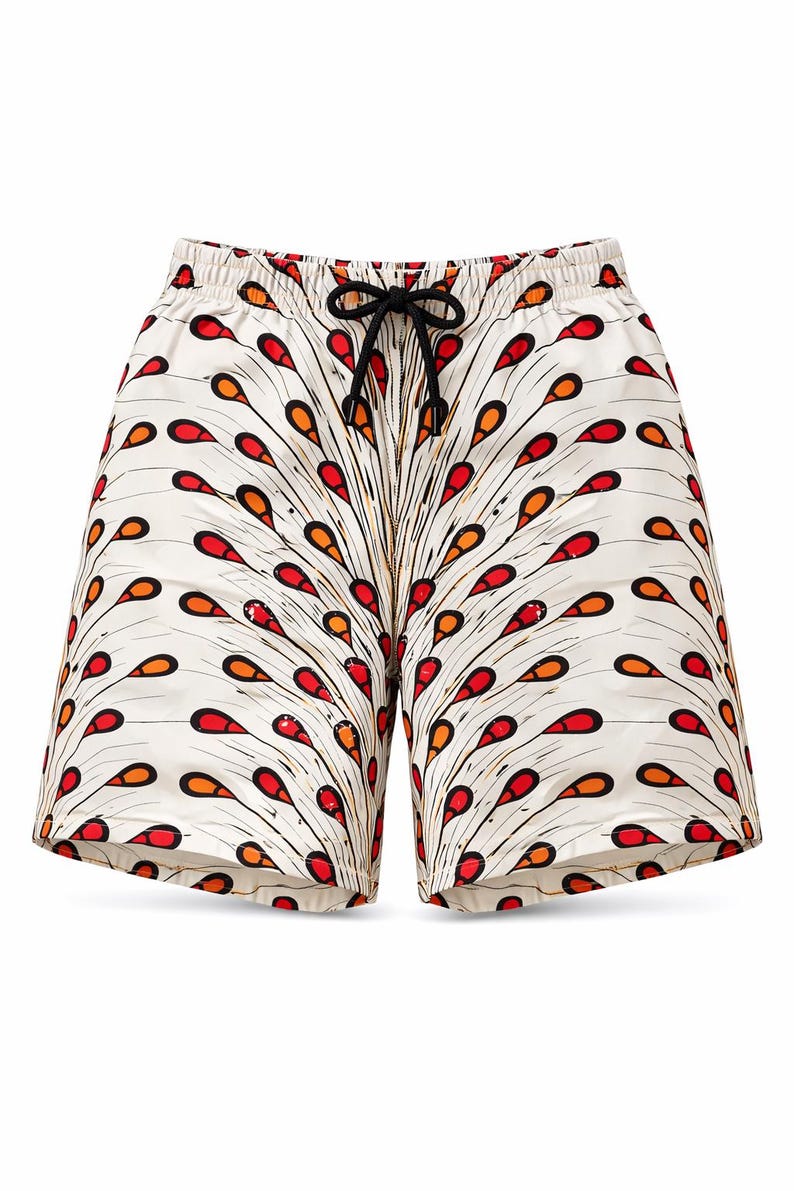 May include: White shorts featuring a colourful pattern of red and orange teardrop shapes. The shorts have a drawstring waist and a black drawstring. These shorts are a summer clothing item.