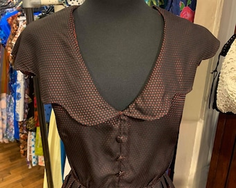 May include: A black and red polka dot dress with a Peter Pan collar and button closure. The dress has short sleeves and a full skirt.