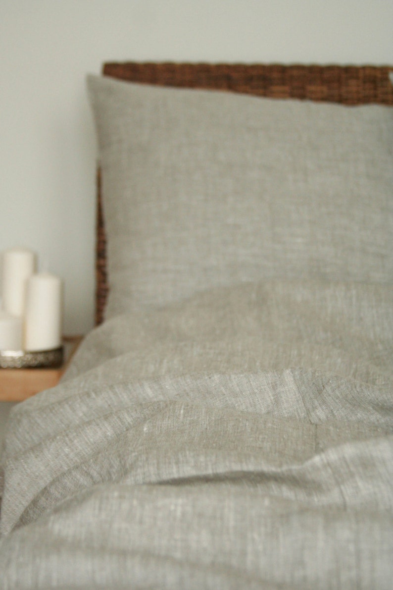 May include: A white ceramic mug with a black handle and the text "But First, Coffee" in a black, handwritten-style font. The mug is sitting on a white surface.