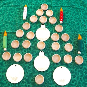 May include: A Christmas-themed arrangement on a green star-patterned background. The display includes wooden bowls, white ornaments, and felt candles in red, green, and white. The ornaments have a leaf design. The arrangement is in the shape of a Christmas tree.